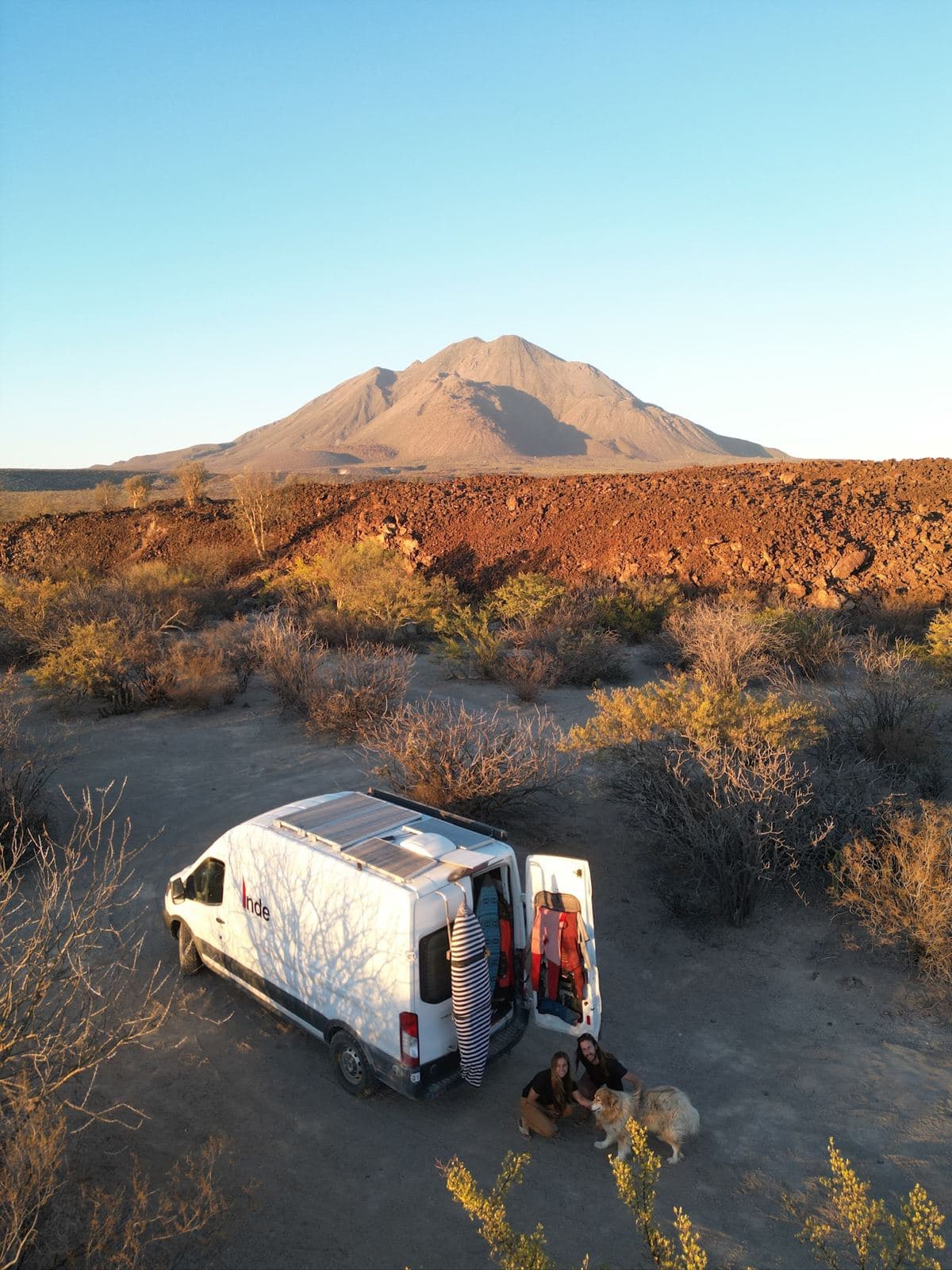 The van parked in the desert below a volcano at sunset
