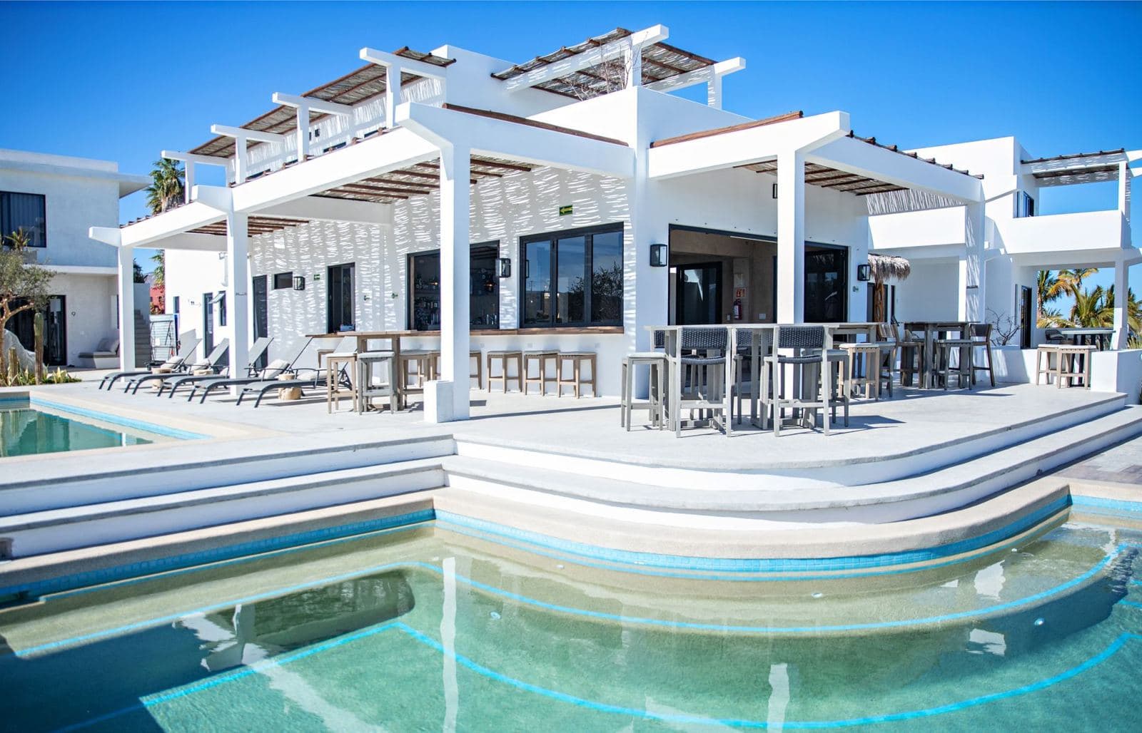 The white hotel buildings behind the pool